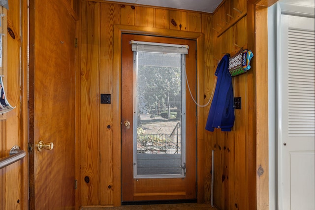 doorway to outside featuring wood walls