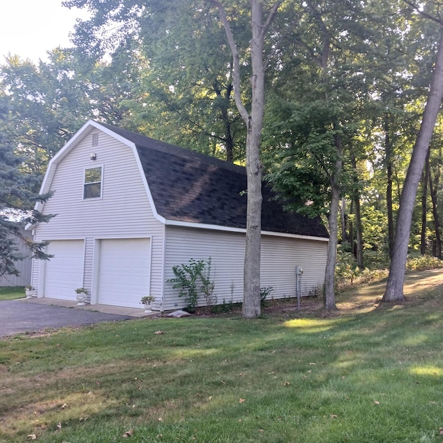 view of side of property featuring a lawn and a garage