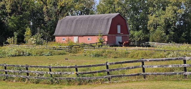 view of outdoor structure featuring a rural view and a lawn