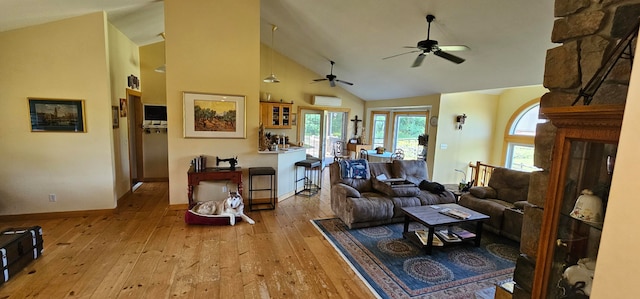 living room featuring ceiling fan, light wood-type flooring, a wall mounted air conditioner, and high vaulted ceiling