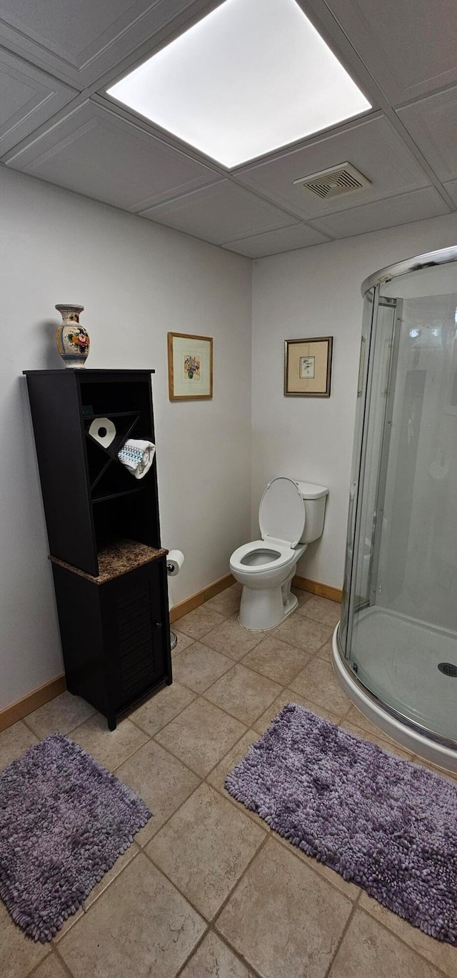 bathroom with toilet, tile patterned flooring, and an enclosed shower