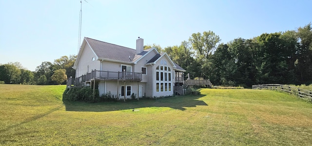 rear view of property featuring a wooden deck and a lawn