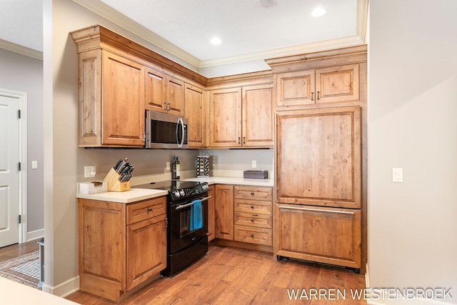 kitchen with black electric range, crown molding, and light hardwood / wood-style flooring