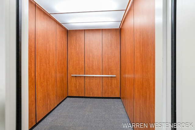 carpeted spare room featuring elevator