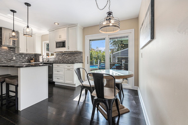 kitchen featuring decorative light fixtures, tasteful backsplash, built in microwave, and white cabinets