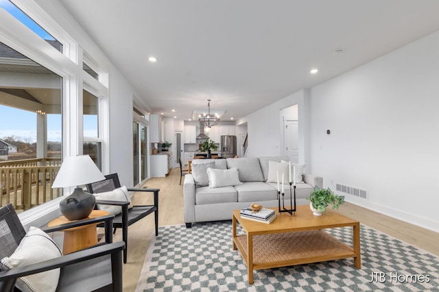 living room featuring light hardwood / wood-style flooring and a notable chandelier