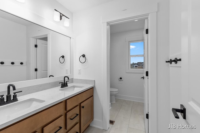 bathroom with tile patterned flooring, vanity, and toilet