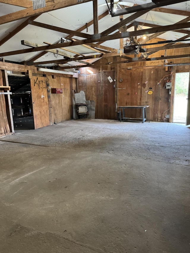 garage with a garage door opener and wooden walls