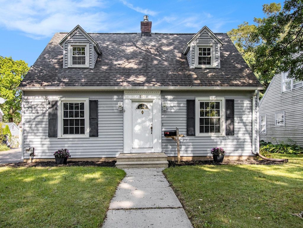 cape cod home with a front yard