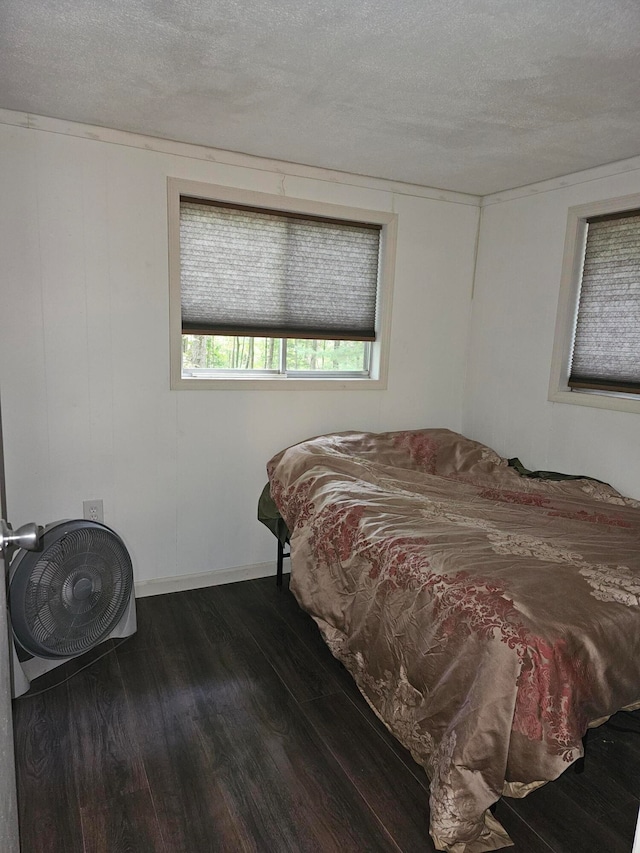 bedroom with dark wood-type flooring and a textured ceiling