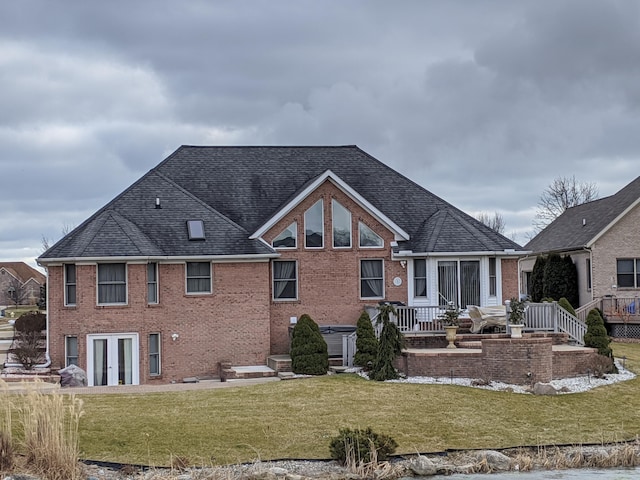 rear view of house featuring french doors and a yard