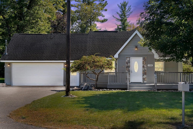 view of front of home with a garage and a lawn