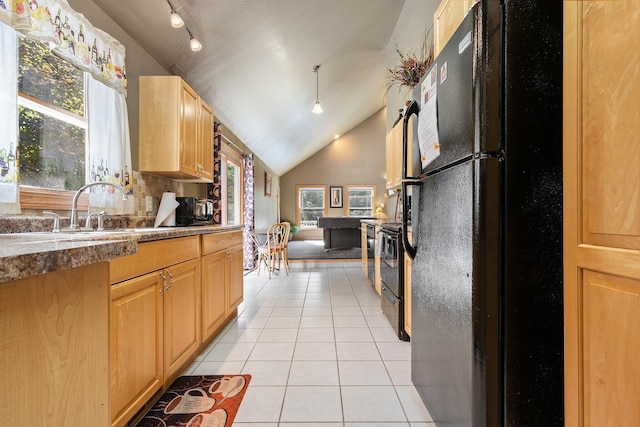 kitchen featuring track lighting, light tile patterned floors, black appliances, sink, and vaulted ceiling