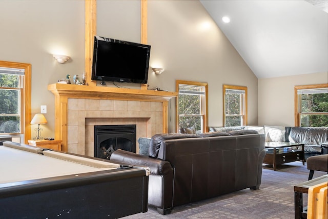 carpeted living room with high vaulted ceiling, a fireplace, and a healthy amount of sunlight