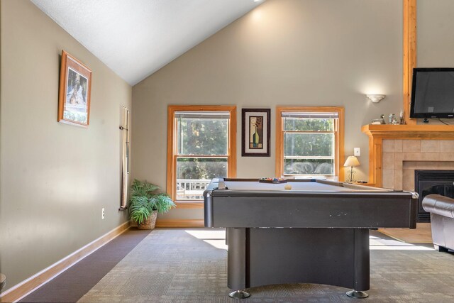 recreation room featuring pool table, a tiled fireplace, high vaulted ceiling, and light carpet