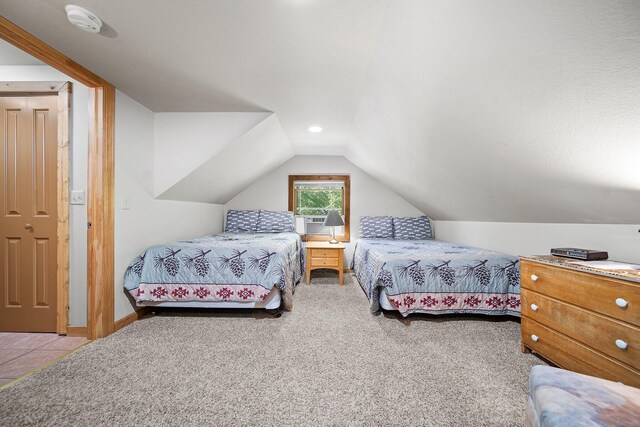 bedroom featuring lofted ceiling and light carpet