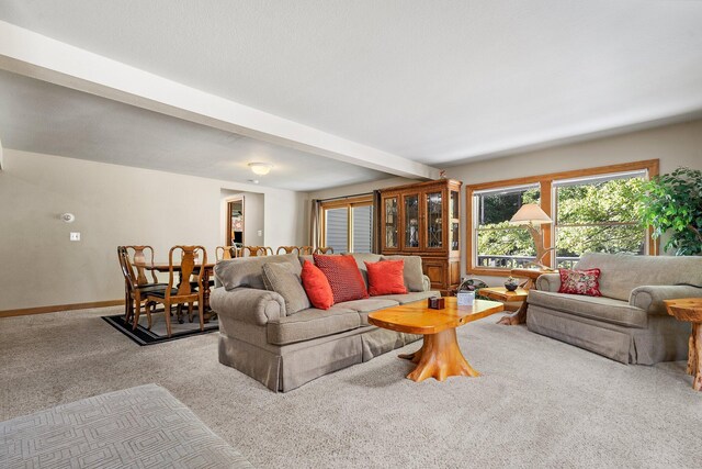 living room featuring light colored carpet and beamed ceiling