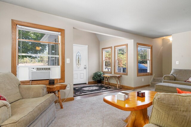 living room featuring lofted ceiling, plenty of natural light, and cooling unit