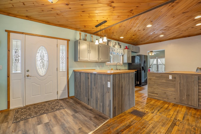 entryway with wood ceiling, plenty of natural light, and dark wood-type flooring