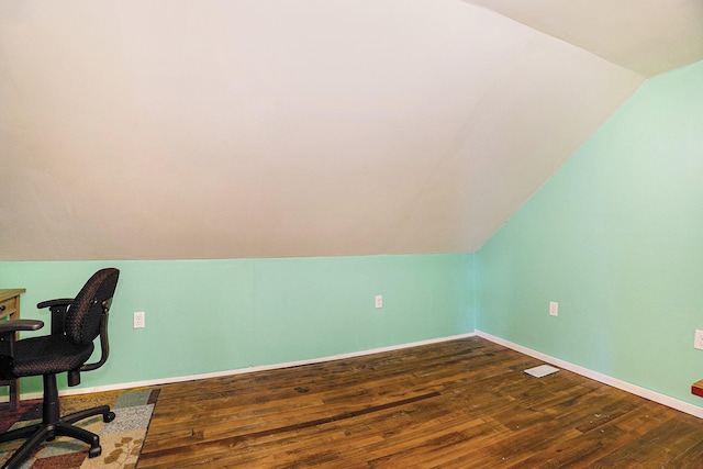 home office featuring vaulted ceiling and dark hardwood / wood-style flooring