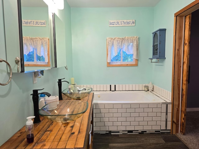 bathroom with tiled bath and vanity