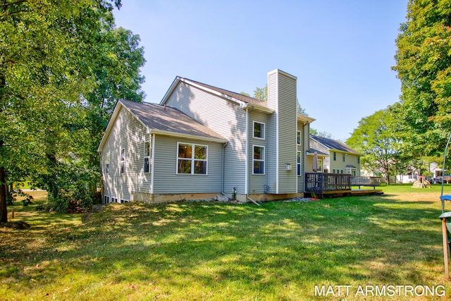 rear view of house with a lawn and a deck