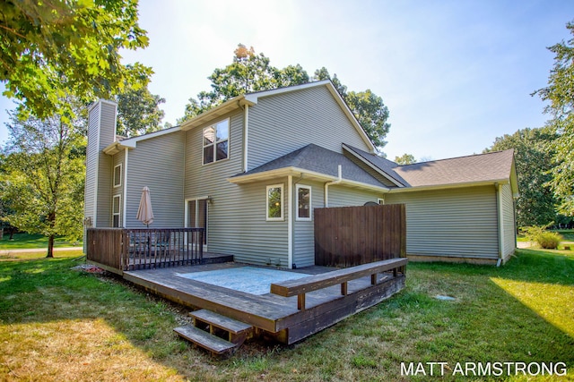 back of house featuring a lawn and a wooden deck