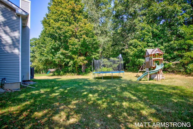 view of yard with a trampoline and a playground