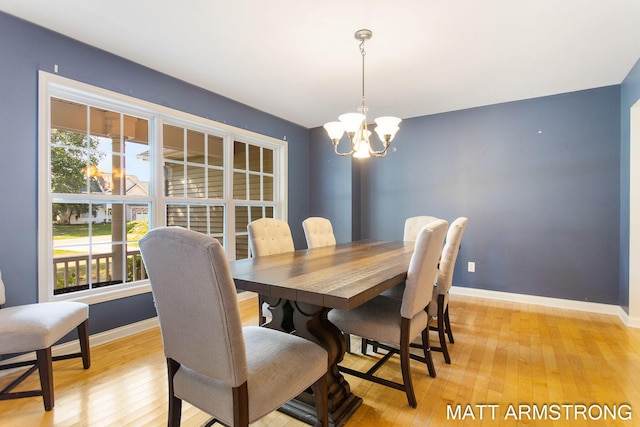 dining area with a wealth of natural light, a notable chandelier, and light hardwood / wood-style floors