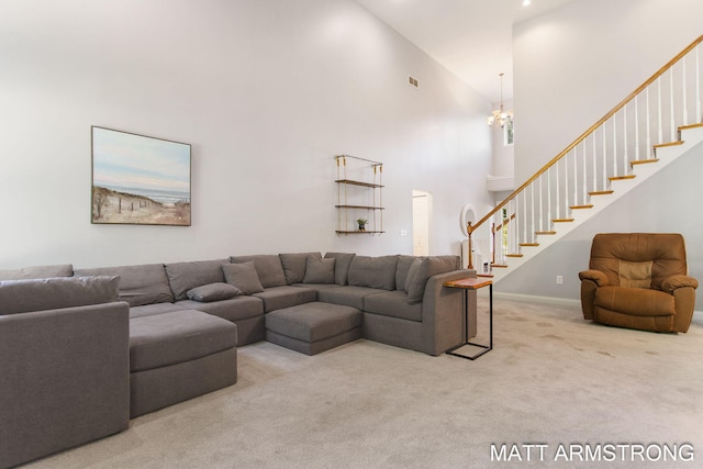 living room featuring carpet flooring, an inviting chandelier, and high vaulted ceiling