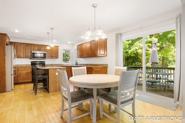 dining space with an inviting chandelier and light hardwood / wood-style floors