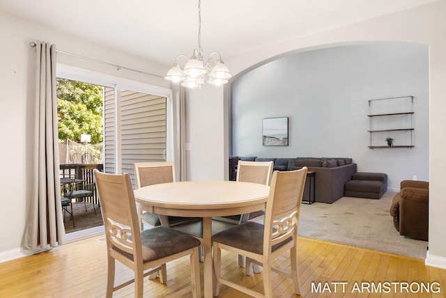 dining space featuring light hardwood / wood-style floors and a notable chandelier