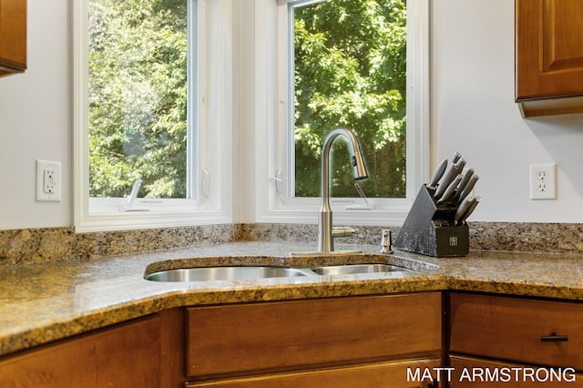 interior space with light stone countertops, a wealth of natural light, and sink