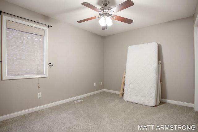 empty room with ceiling fan, plenty of natural light, and light carpet