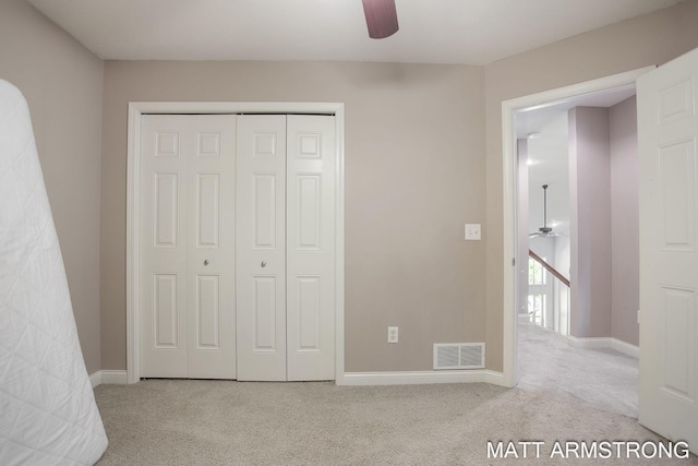 unfurnished bedroom with ceiling fan, a closet, and light carpet