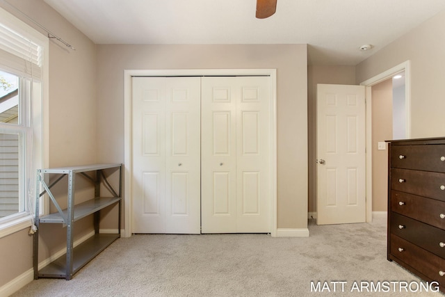 bedroom featuring a closet, ceiling fan, and light carpet