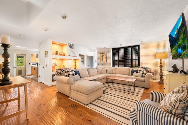 living room featuring light hardwood / wood-style flooring and a textured ceiling