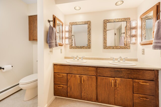 bathroom with vanity, toilet, and a baseboard heating unit