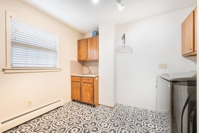 laundry area with washer and dryer, sink, a baseboard heating unit, and cabinets