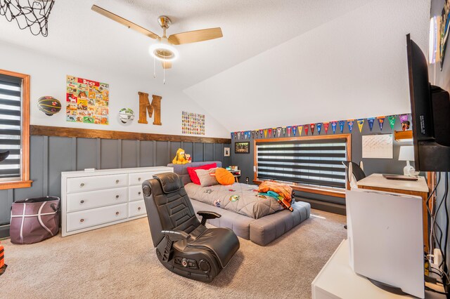 interior space with lofted ceiling, ceiling fan, and light carpet