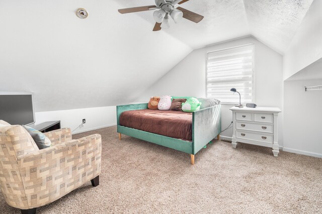 bedroom with light carpet, lofted ceiling, ceiling fan, and a textured ceiling