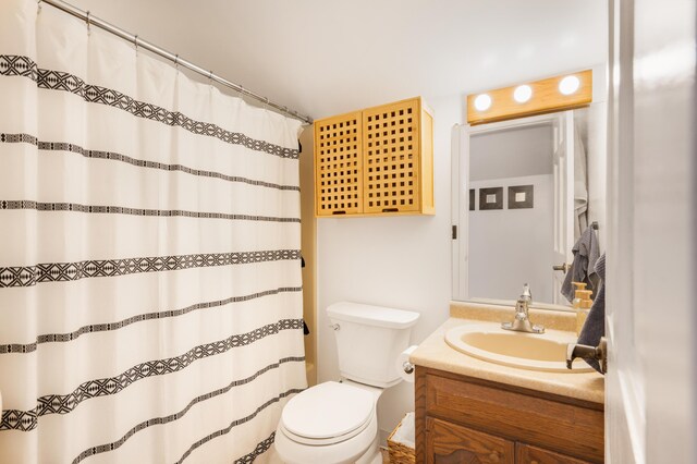 bathroom featuring walk in shower, vanity, and toilet