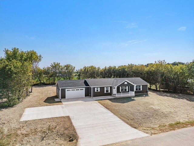 single story home featuring a porch and a garage