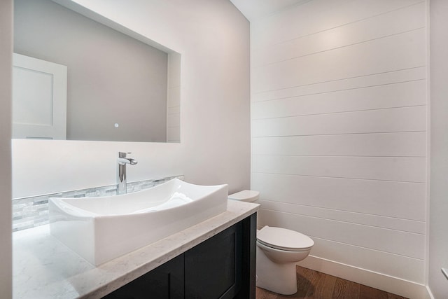 bathroom featuring wood-type flooring, vanity, and toilet