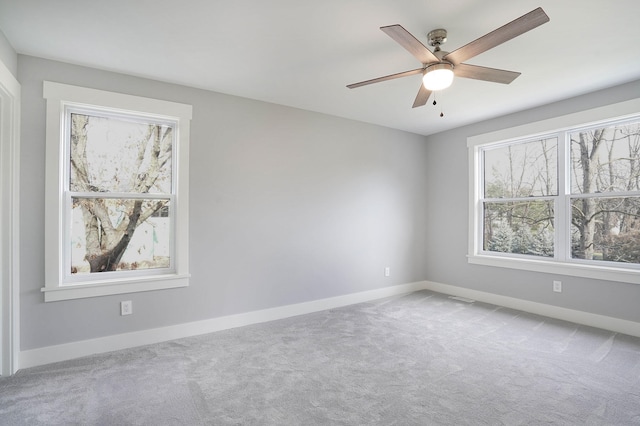 carpeted spare room featuring ceiling fan