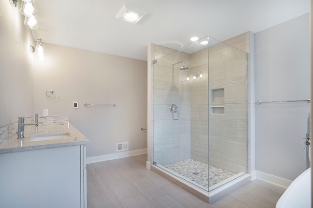 bathroom with a shower with door and vanity