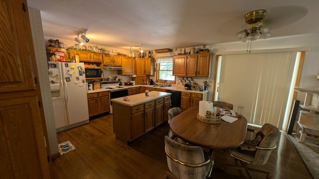 kitchen featuring black appliances, a kitchen island, sink, ceiling fan, and dark wood-type flooring