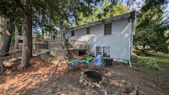 rear view of property with an outdoor fire pit and a deck