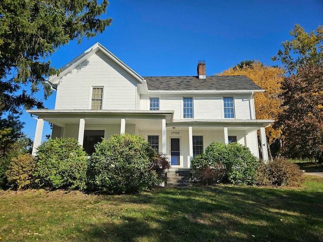 view of front of property featuring covered porch and a front yard