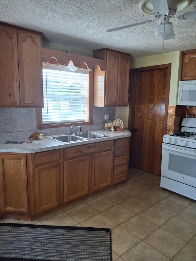 kitchen with light tile patterned flooring, backsplash, white appliances, ceiling fan, and sink